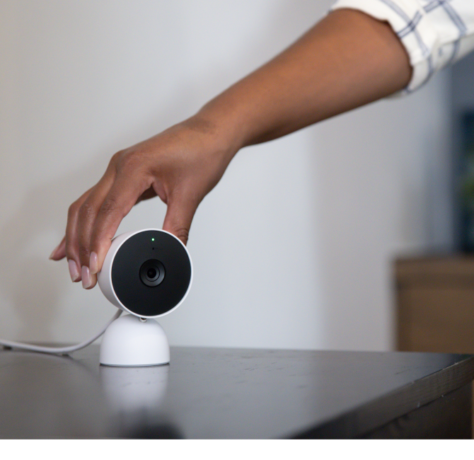 Person putting the Google Nest Indoor cam on a desk