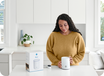 Woman with the ADT hub in her kitchen