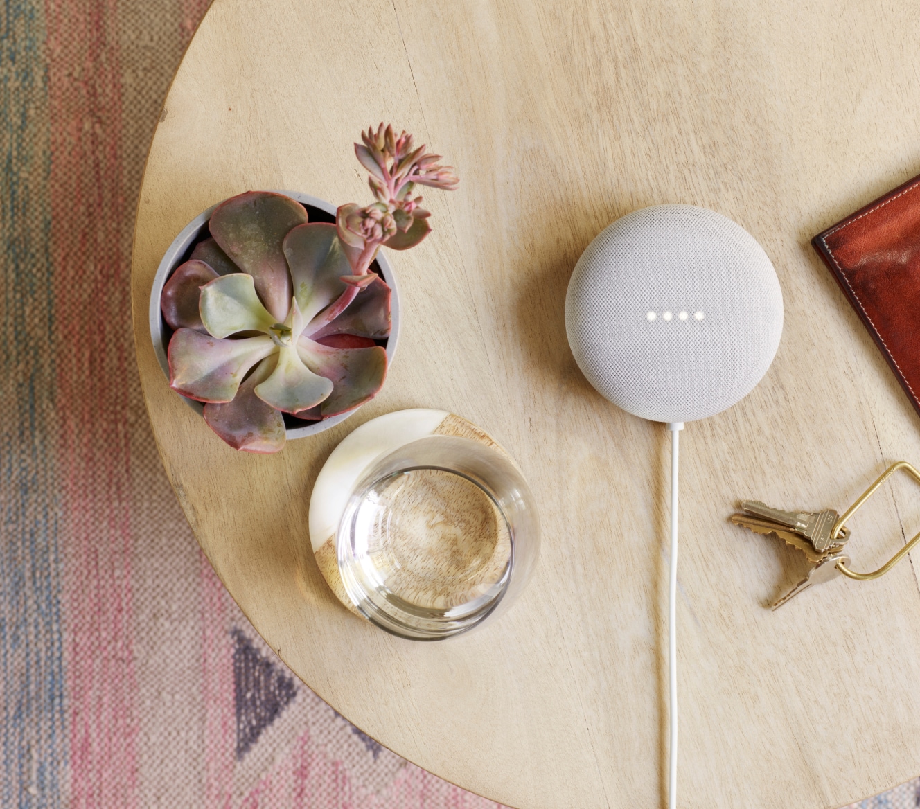 Google Nest Mini on a table with succulent and house keys