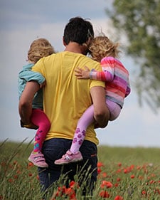 Father carrying two children