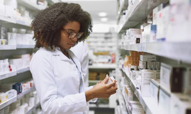 Lab worker examining prescription bottle Lab worker examining prescription bottle