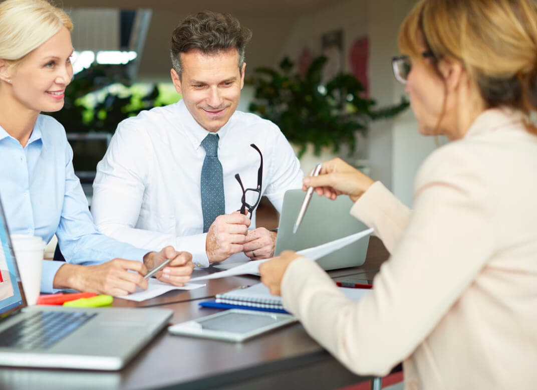 Woman consults with two customers on security solutions Woman consults with two customers on security solutions