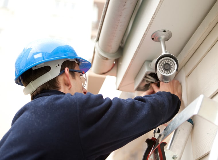 ADT worker installing ADT camera to a home