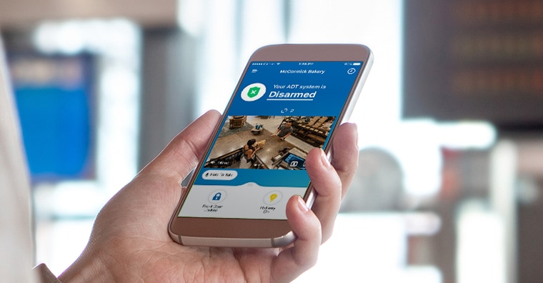 Hand holding cell phone with the ADT app