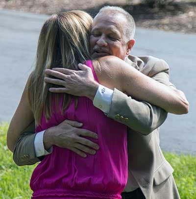 ADT dispatcher Greg Drinnen gives Sue Brodsky a hug.