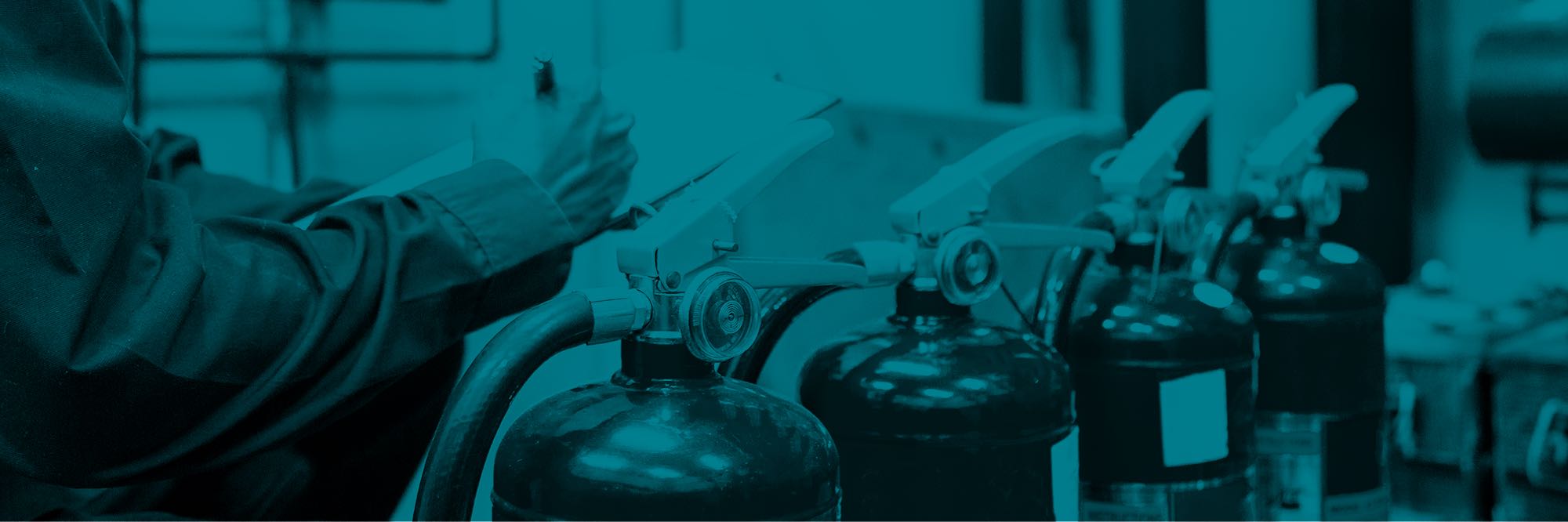 Man with clipboard checking row of fire extinguishers