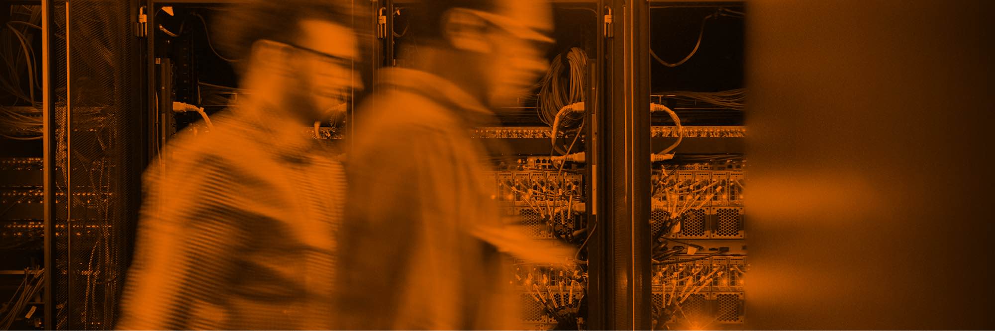 Two men walking past server racks