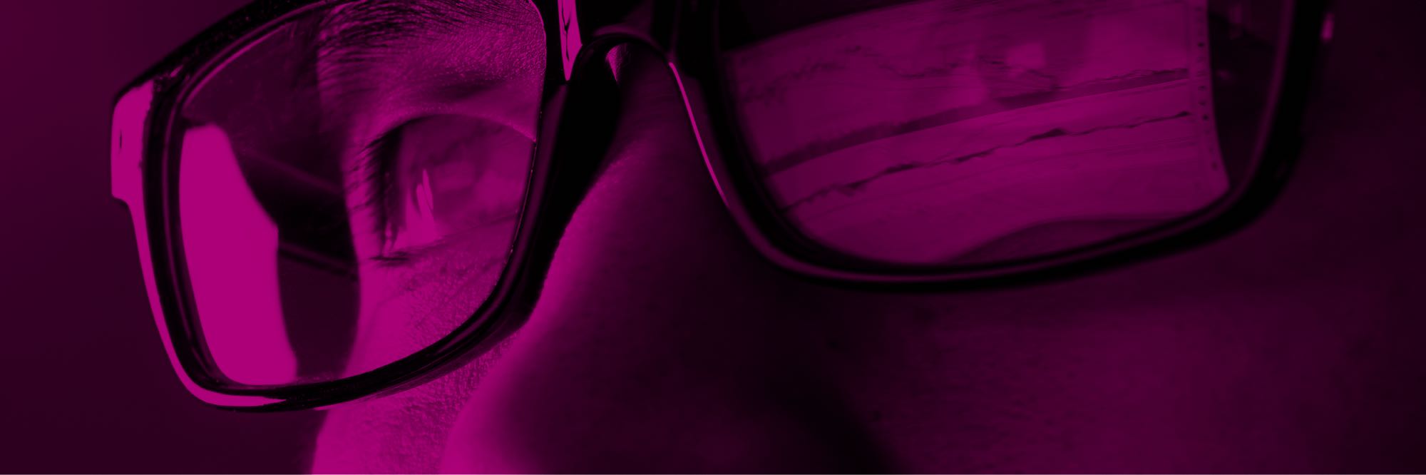 Close-up of man with monitoring data reflected in his glasses