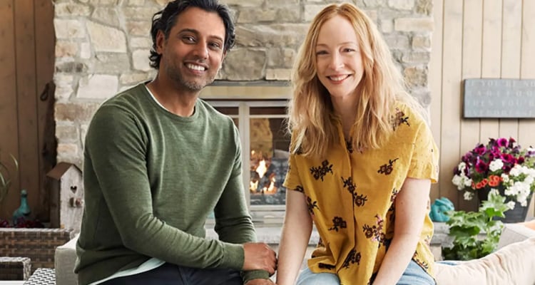 Married couple sitting in front of their fireplace in their ADT armed home, enjoying their life safety products, and smiling 
