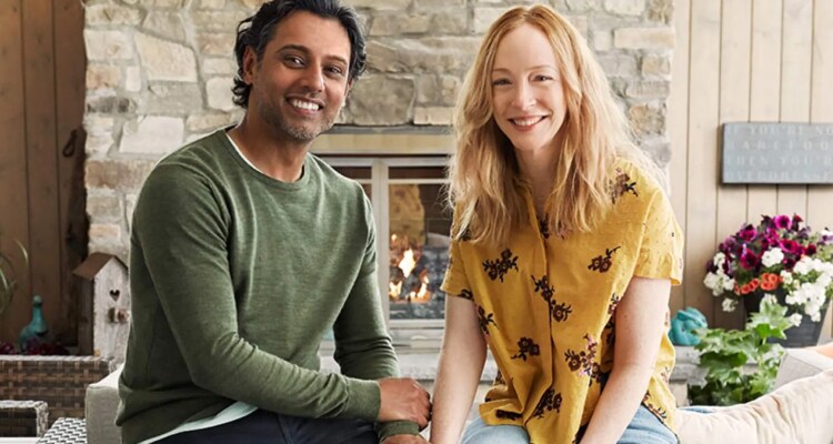 Married couple sitting in front of their fireplace in their ADT armed home, enjoying their life safety products, and smiling