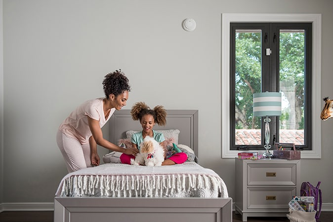 An image of a mother and her child playing with a puppy on the bed An image of a mother and her child playing with a puppy on the bed