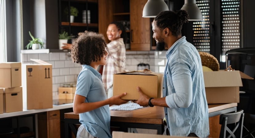 Smiling family unpacking boxes in their new kitchen, symbolizing the start of a new chapter and the importance of securing a new home.