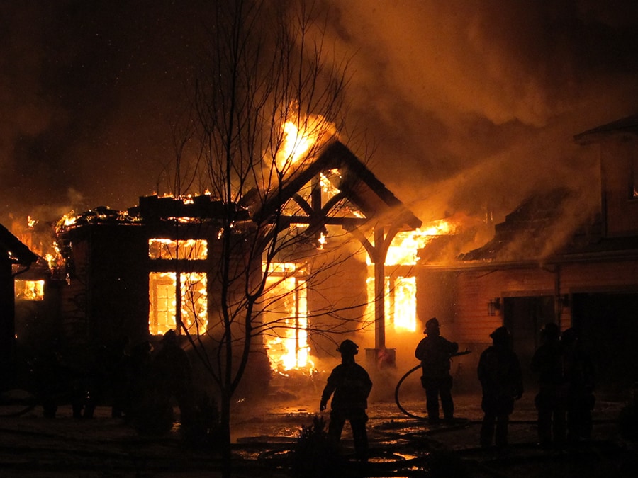 Firefighters fighting a house fire at night. Firefighters fighting a house fire at night.
