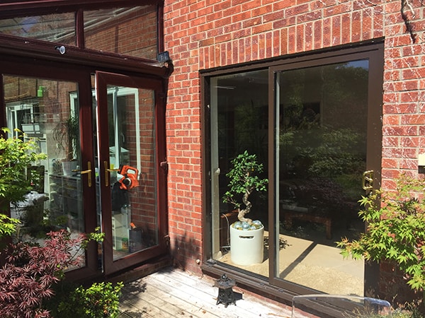 Outside shot of a brick home with glass patio doors.
