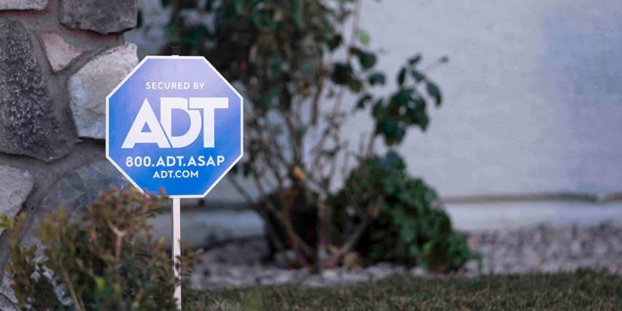 ADT yard sign in front of smart home