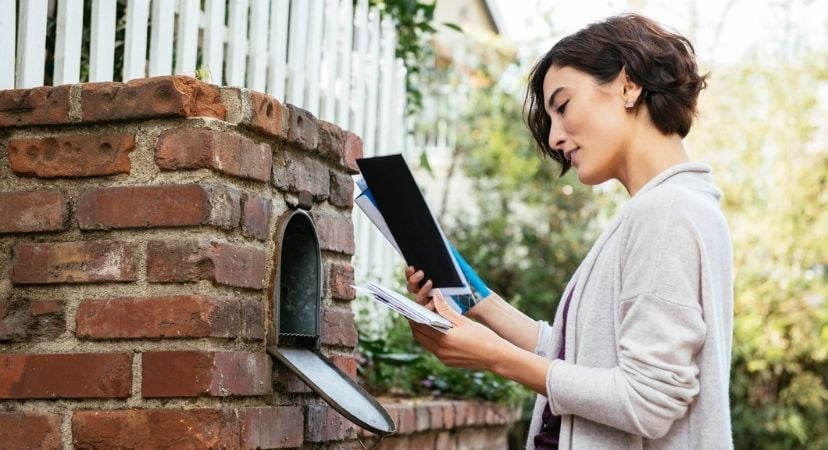 Where Do I Need to Change My Address When Moving? Woman looking at letters from her mailbox