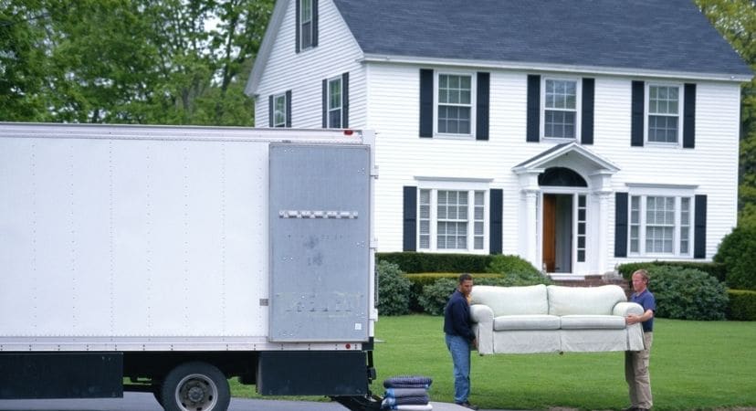 Movers moving a couch from a moving truck