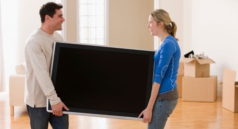Easy Steps to Keep Your TV Safe When Moving Man and woman carrying a tv out of their home