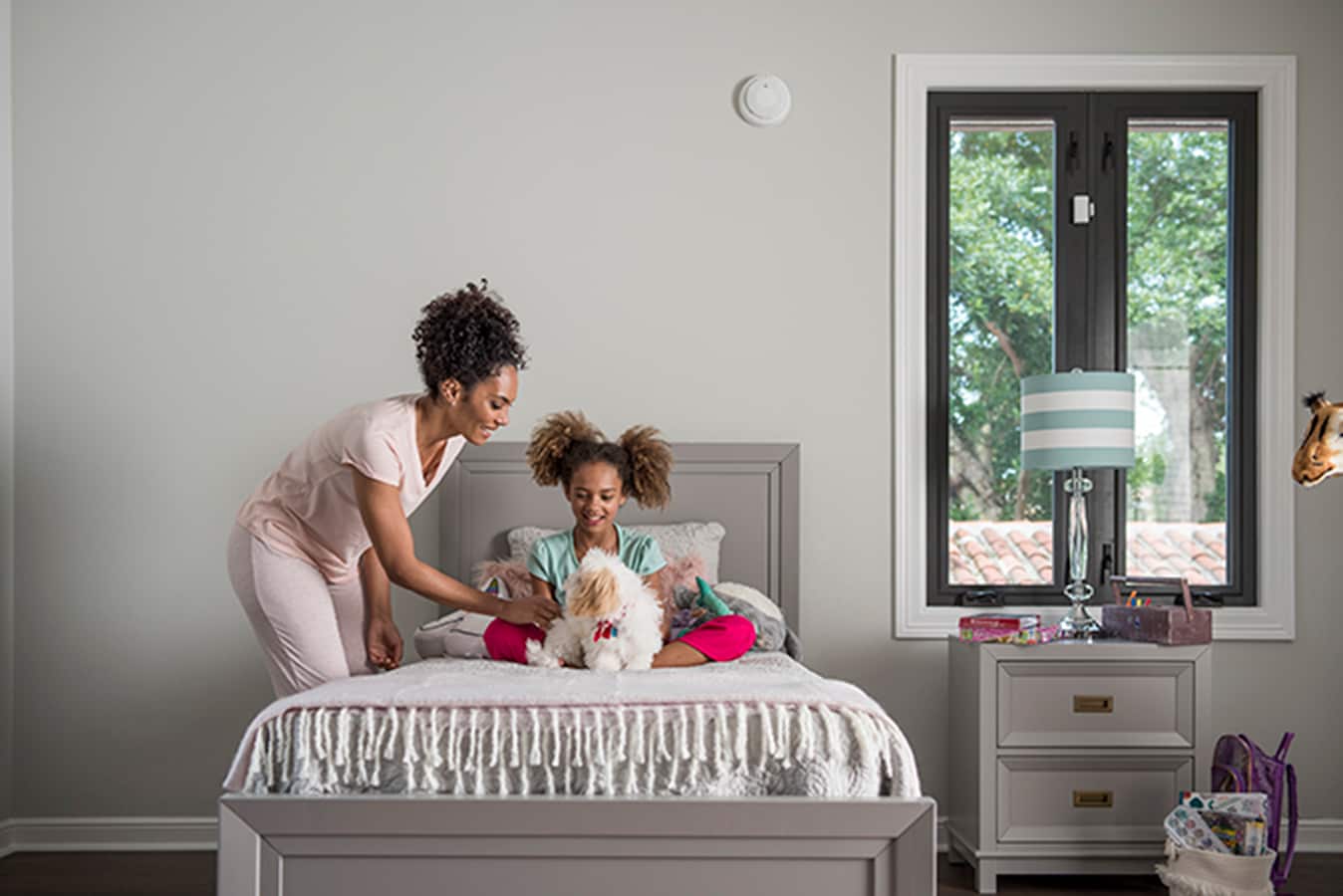 Mother and daughter in bedroom with ADT carbon monoxide alarm. Mother and daughter in bedroom with ADT carbon monoxide alarm.