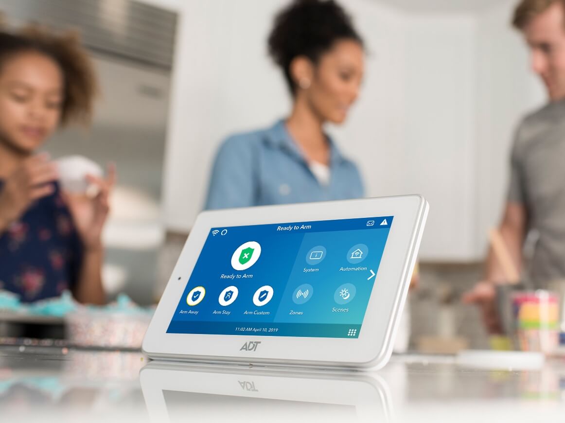 ADT Command Panel on kitchen counter with family in the background