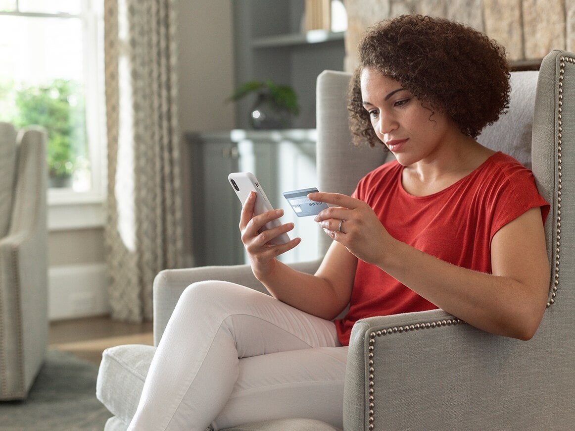 Women using her ADT cellphone app to view fraud and identity alerts 