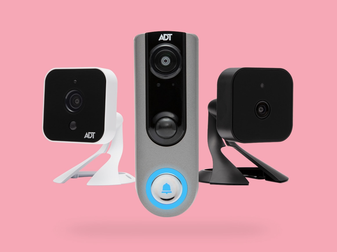 ADT indoor camera in white, ADT doorbell, and ADT indoor camera in black against a pink background