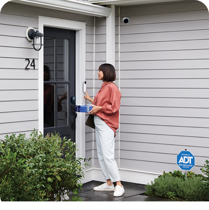 Woman delivering a gift at a house protected by ADT