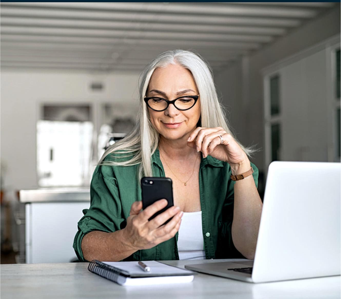 Woman looking at her ADT app on her phone in her home