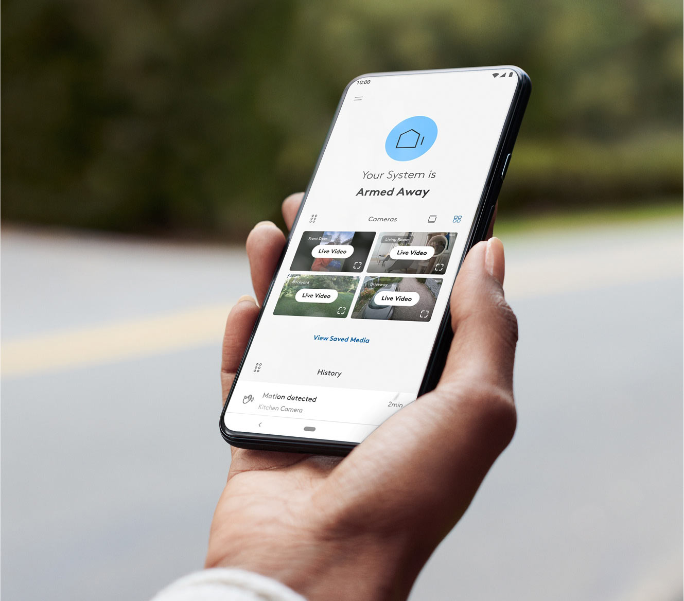 Hand holding a phone showing the ADT+ app