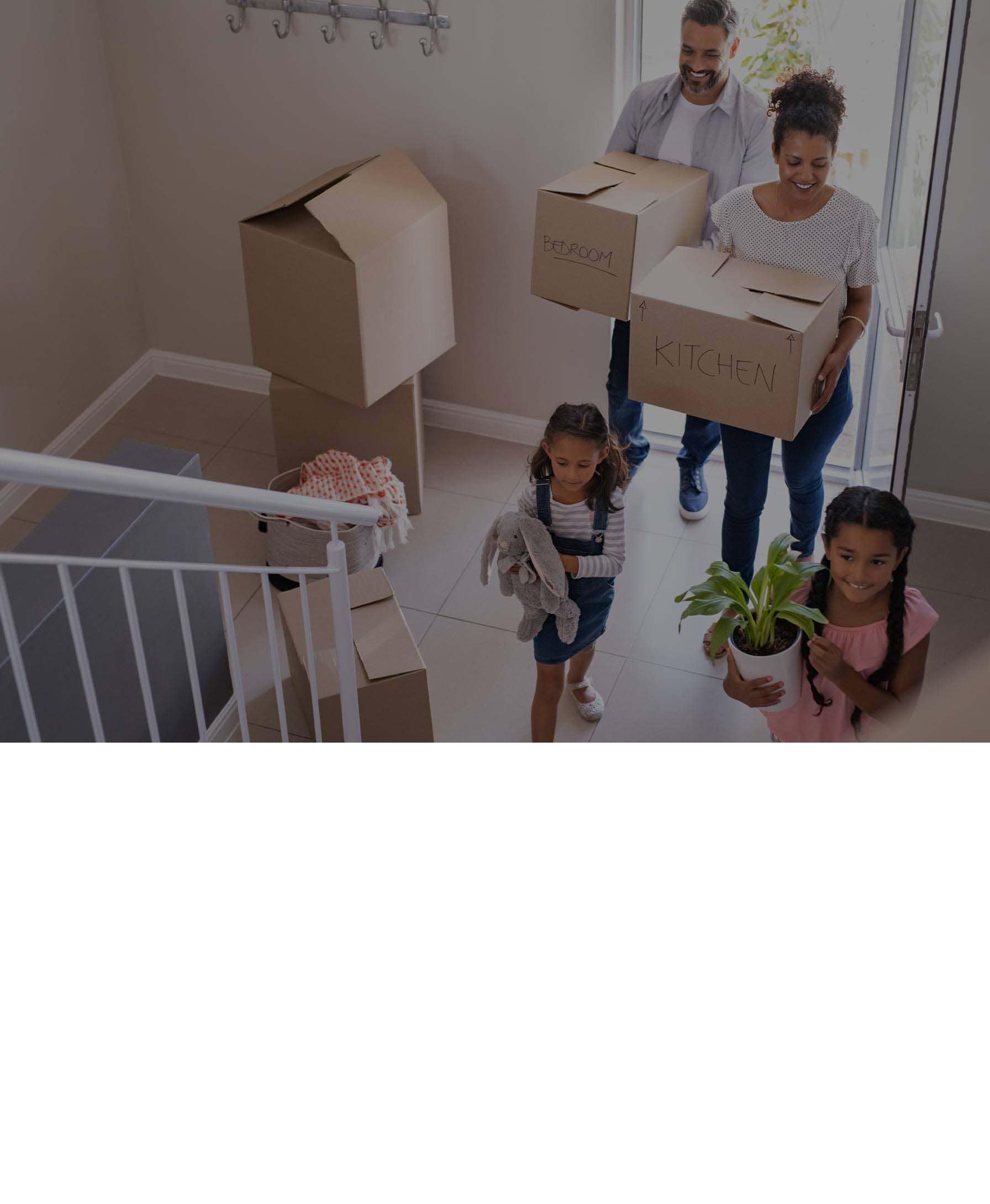 Family moving into a new home - carrying boxes and toys