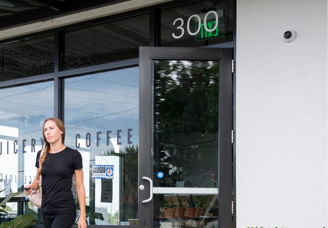The front entrance of a business with a visible ADT security sticker and mounted surveillance camera.