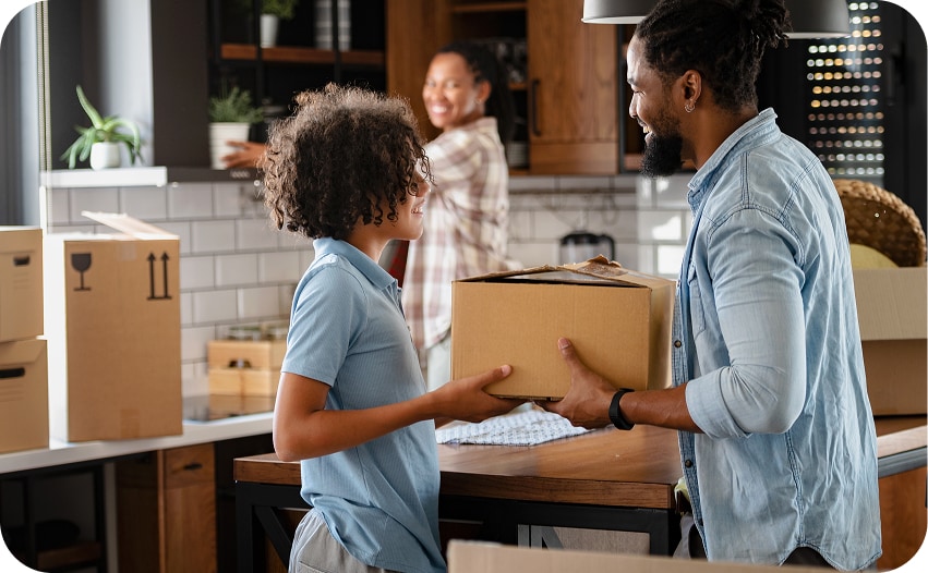 Father and child unpacking moving boxes in a new home's kitchen