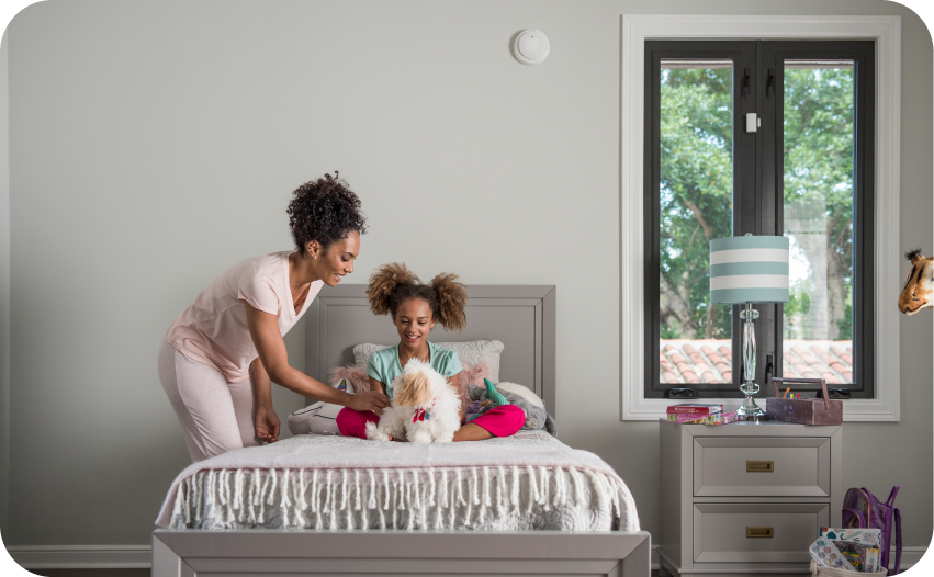 Mother and young daughter playing on a bed in a cozy bedroom