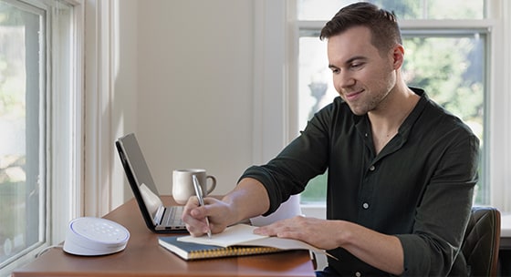 Homeowner reviewing insurance policy with home security system in the background