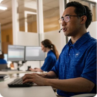 ADT Monitoring agent with headset in call center on computer