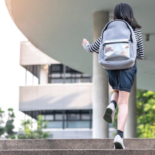 Child with backpack ascending steps