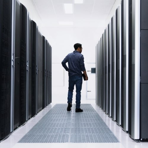 Man standing among server towers