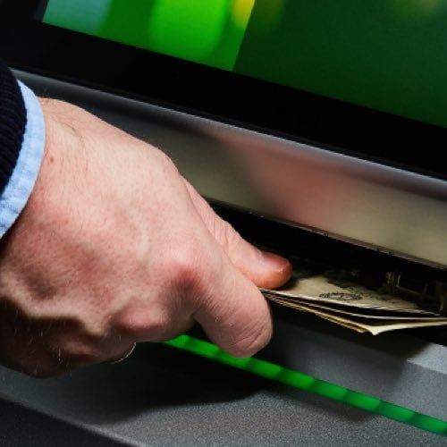 Hand withdrawing cash from ATM