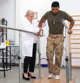 Man in wheelchair talking to doctor in hallway