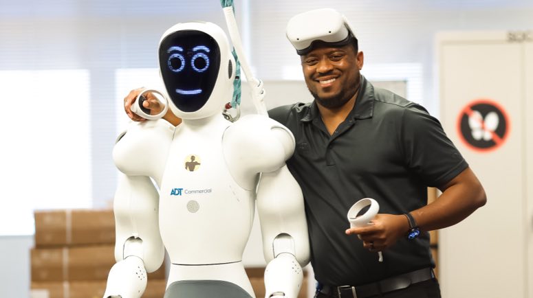 Operator with arm around shoulder of robot