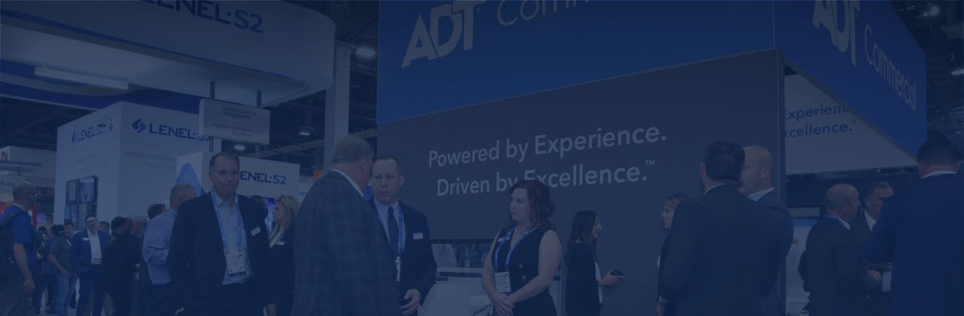 ADT Commercial tradeshow booth with Powered by Experience, Driven by Excellence sign
