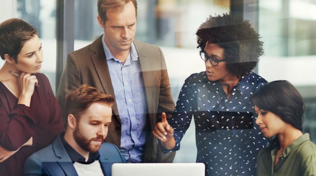 Group of people conferring around a laptop