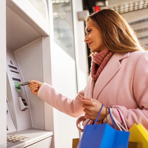 Woman inserting card into ATM