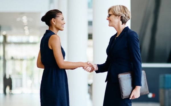 Women shaking hands in lobby