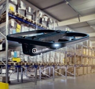 Drone flying down aisle of warehouse