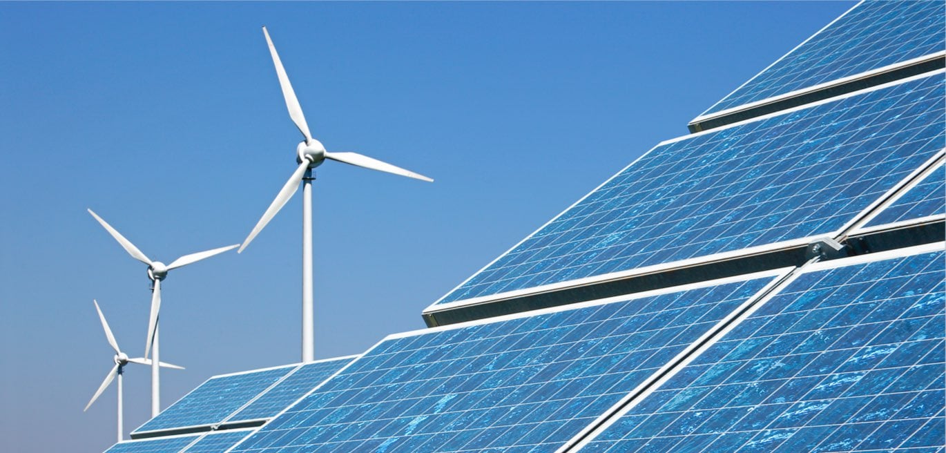 Wind Turbines and solar panel arrays before blue sky