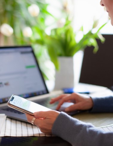 Woman in office with phone and laptop