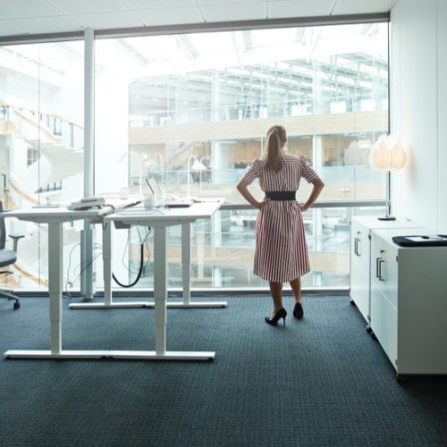 Woman in office gazing out into atrium