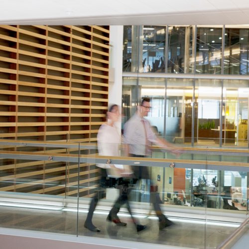 Coworkers crossing an atrium bridge