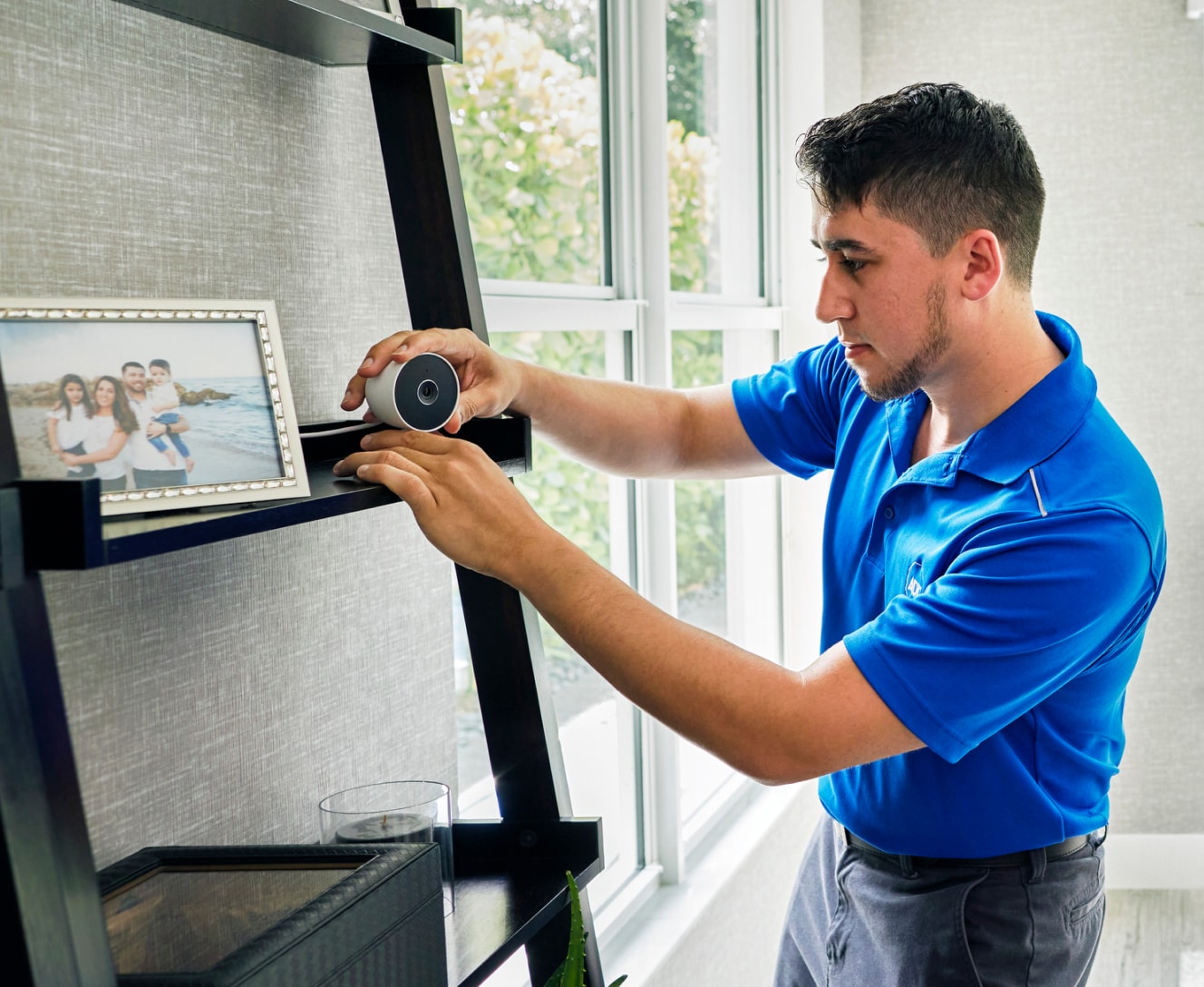 ADT Installer placing a Google Nest doorbell on a house